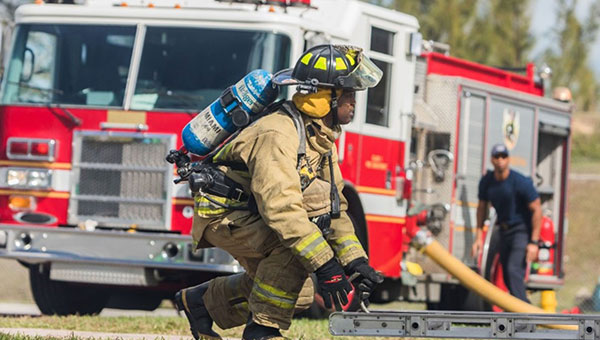 Firefighter during training in front of a firetruck Firefighter during training in front of a firetruck
