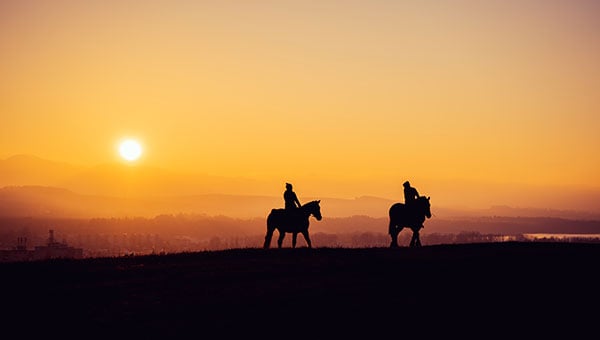 two-people-horseback-sunset two-people-horseback-sunset